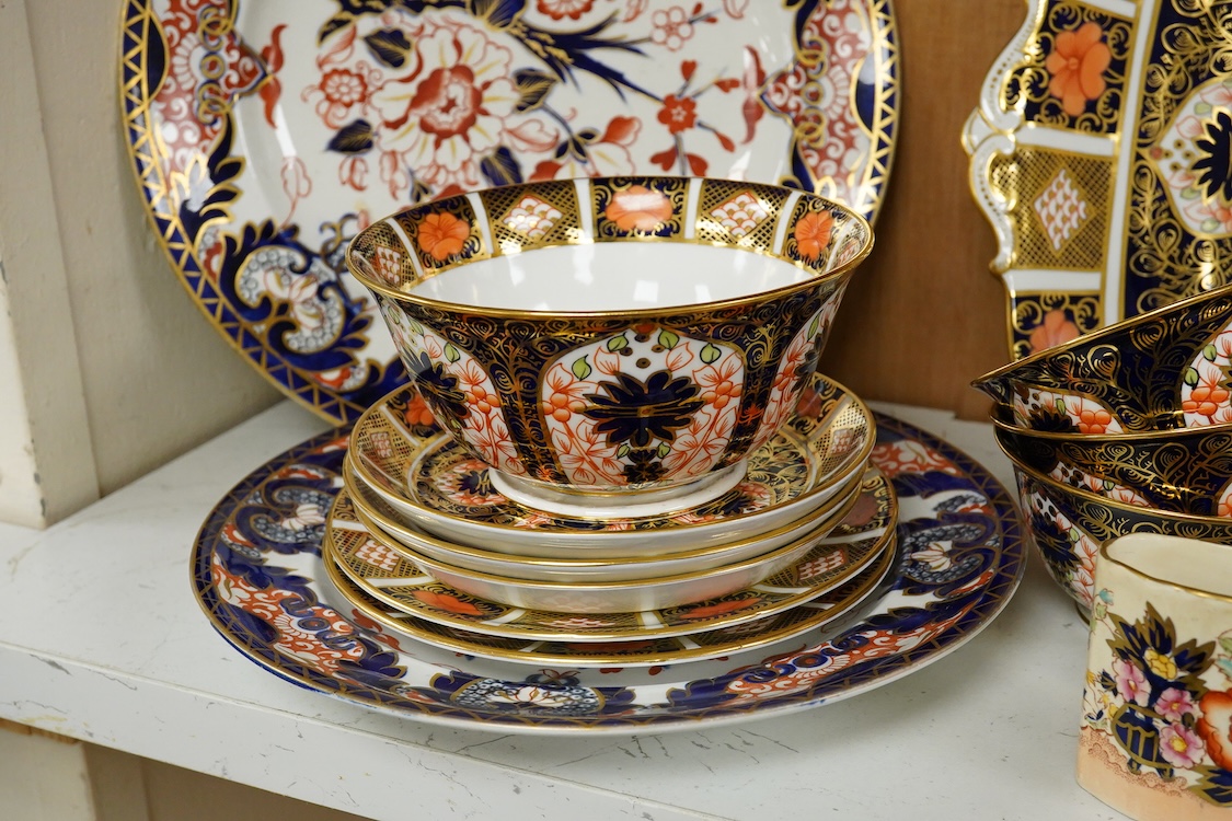 A quantity of Royal Crown Derby Imari to include a sandwich plate, cups and saucers and and miniature twin handled cups, largest 27cm in diameter